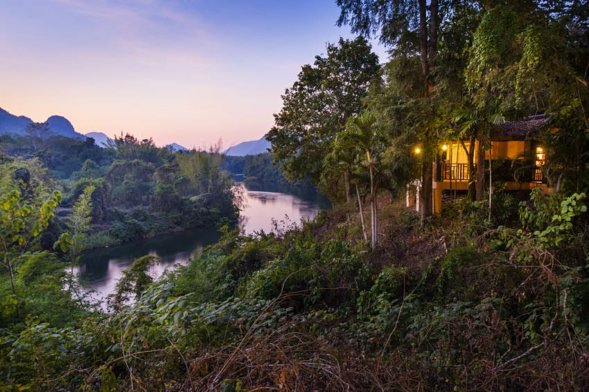 Phutoey Resort sits above a picturesque bend in the Khwai river at sunset Kanchanaburi Thailand